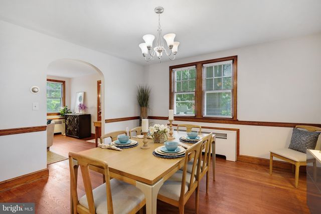 a view of a dining room with furniture a chandelier and wooden floor