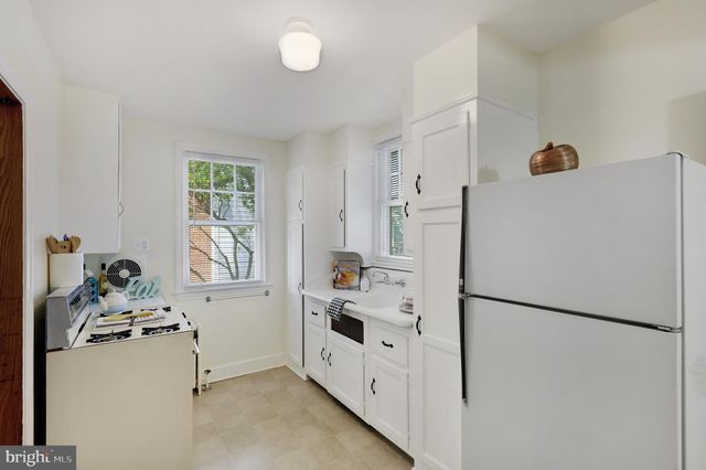 a kitchen with a refrigerator a stove a washer and a window