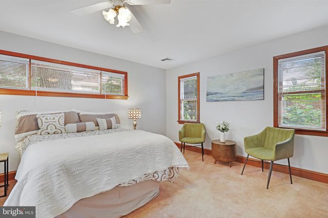 a bedroom with a bed a chair and a chandelier