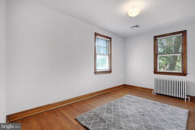 an empty room with wooden floor and a window
