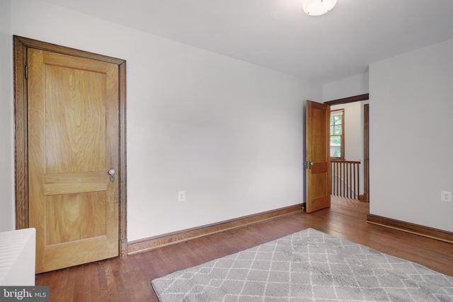 a bedroom with a bed and a lamp on dresser