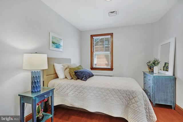 a bedroom with a bed and a painting on the wall