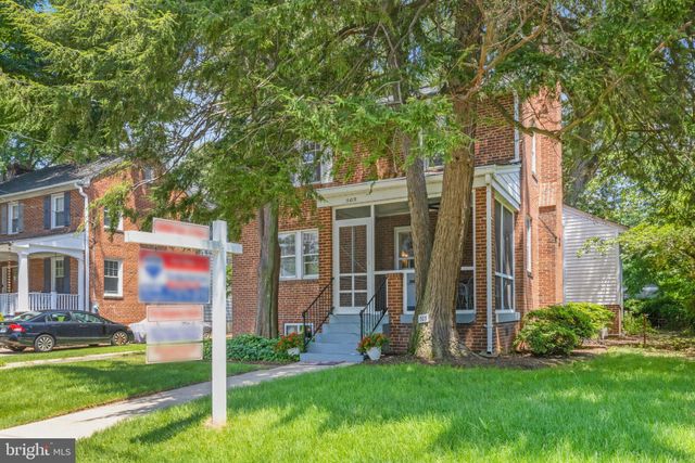 a view of a house with a yard and a large tree