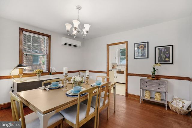 a view of a dining room with furniture a chandelier and wooden floor