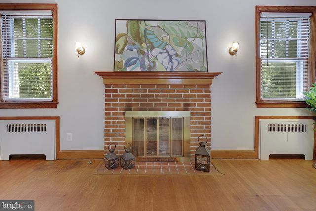 a view of an empty room with a fireplace and window