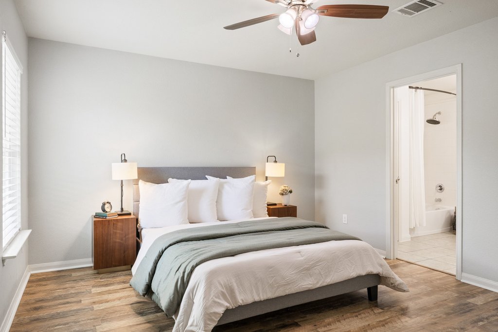 217 Farmer Lane Jarrell, TX 76537 - Photo 13 of 29 Wood-type flooring and a window offering backyard views define this peaceful primary bedroom.