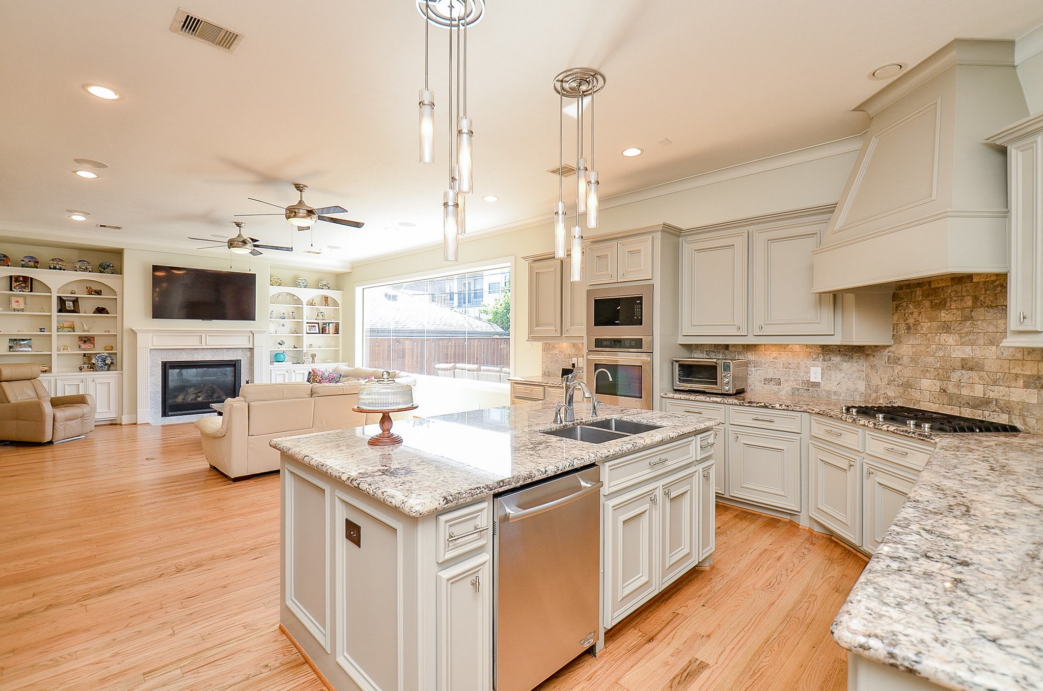 4625 Maple Street Bellaire, TX 77401 - Photo 21 of 47 a kitchen with stainless steel appliances granite countertop a stove top oven a sink dishwasher and a fireplace with wooden floor