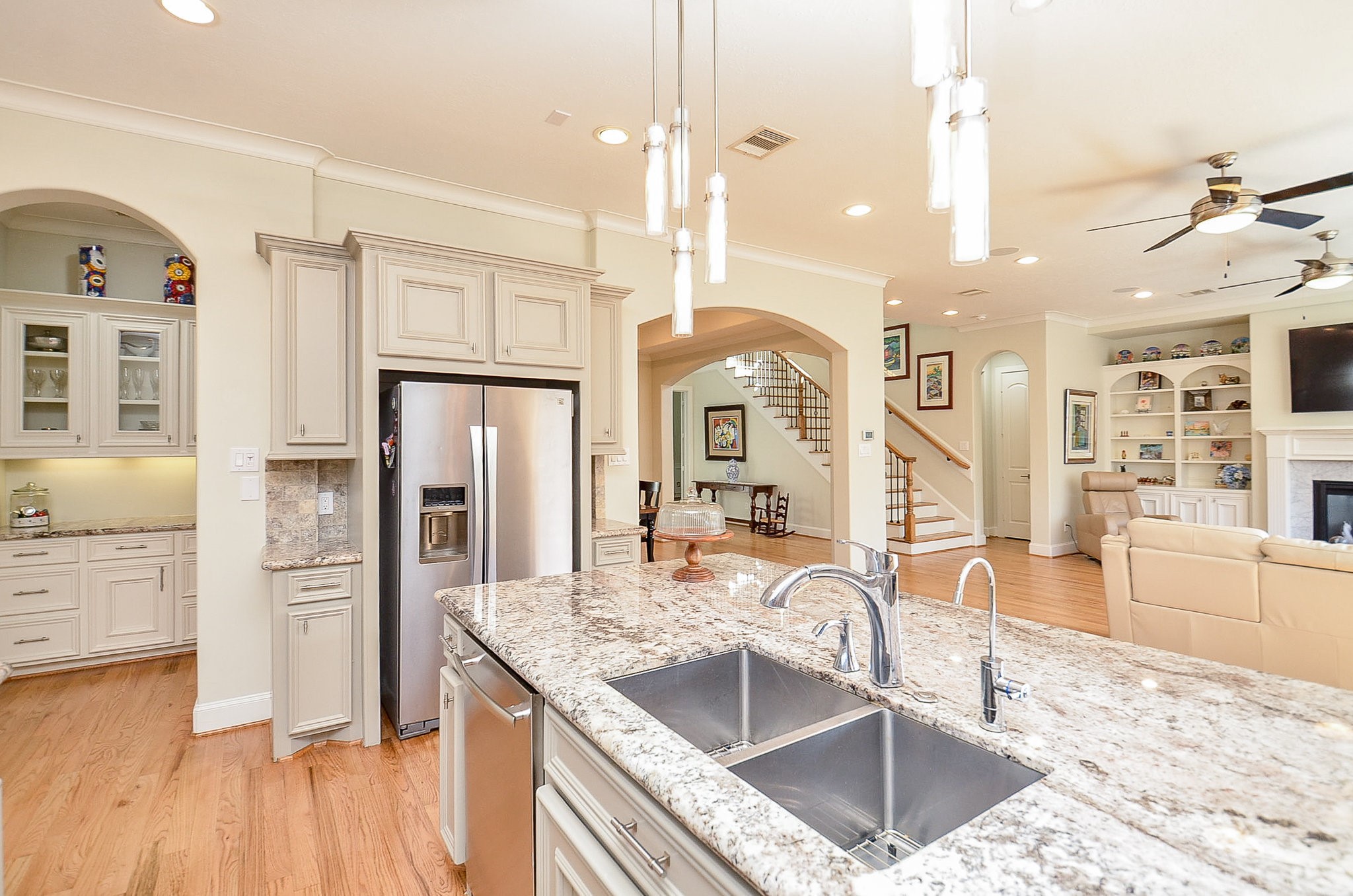 4625 Maple Street Bellaire, TX 77401 - Photo 22 of 47 a kitchen with stainless steel appliances granite countertop a refrigerator a oven and white cabinets with wooden floors