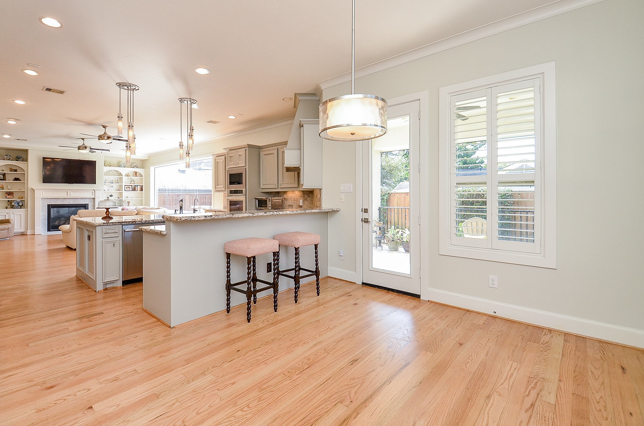 4625 Maple Street Bellaire, TX 77401 - Photo 23 of 47 a open kitchen with stainless steel appliances granite countertop a stove top oven a refrigerator a dining table and chairs with wooden floor
