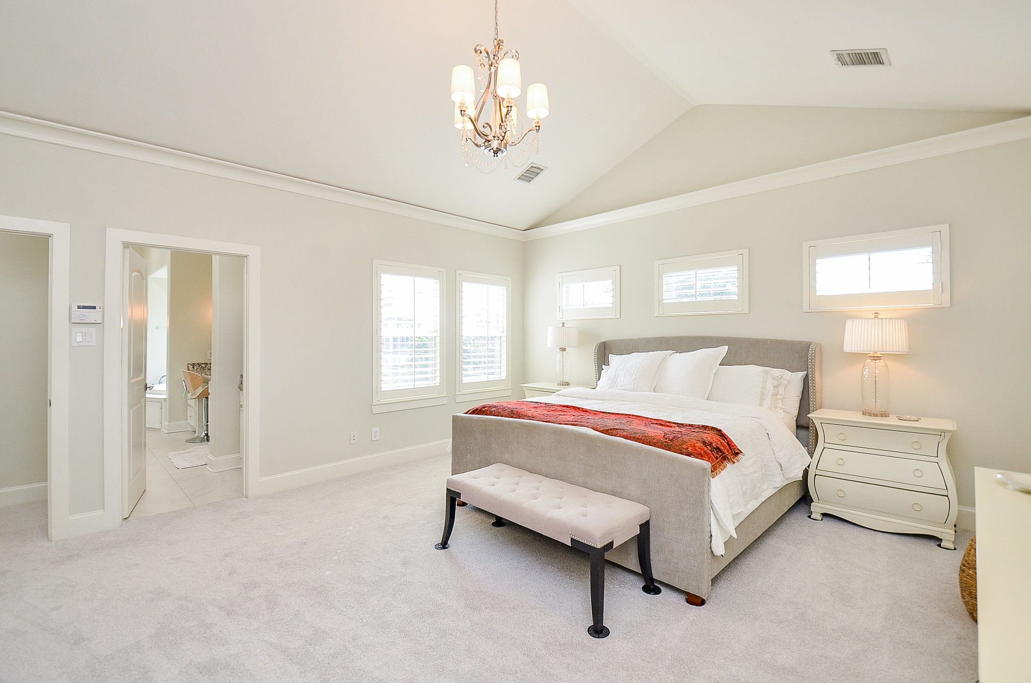 4625 Maple Street Bellaire, TX 77401 - Photo 30 of 47 a spacious bedroom with a bed and a chandelier