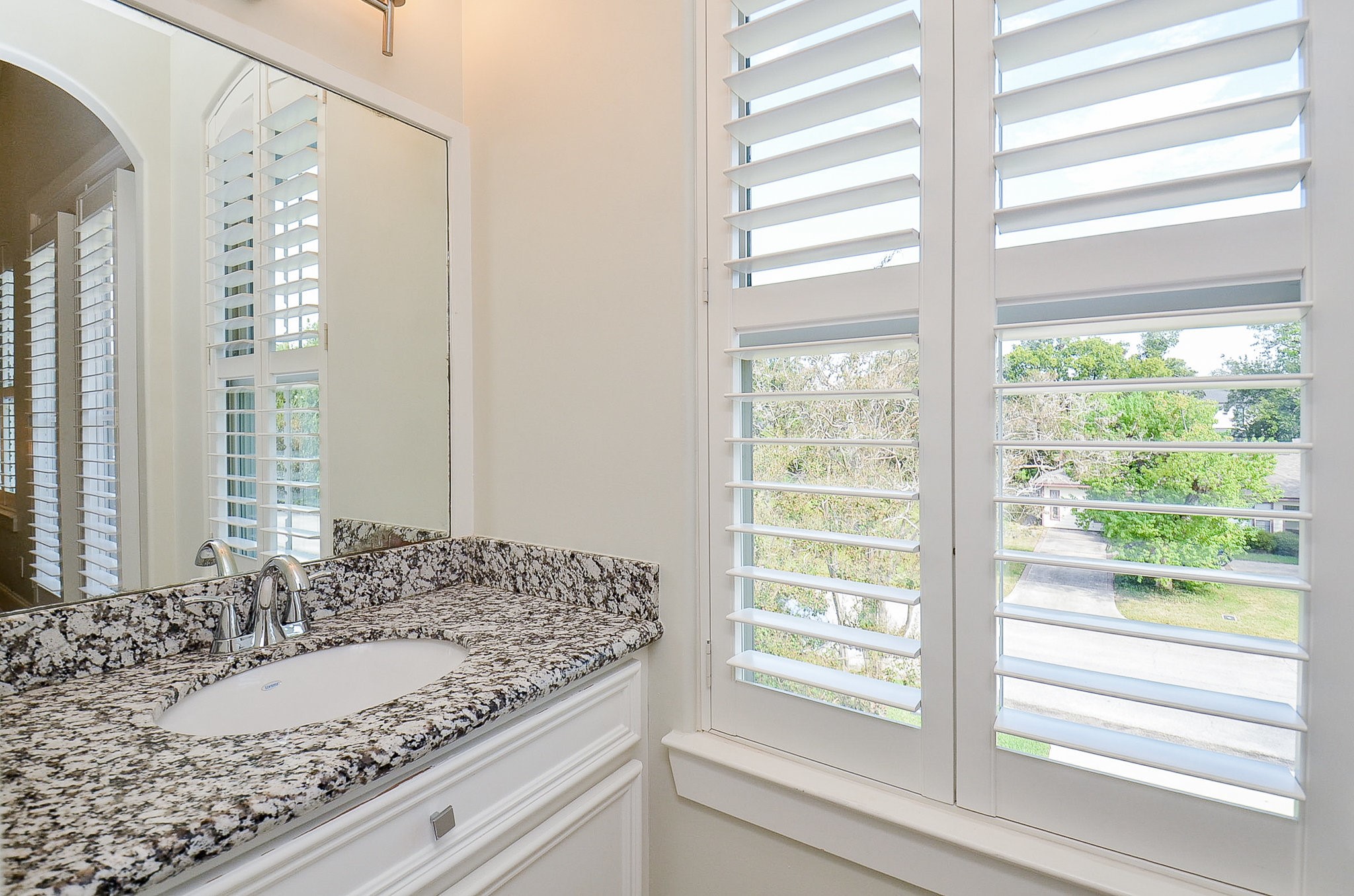 4625 Maple Street Bellaire, TX 77401 - Photo 39 of 47 a bathroom with a granite countertop sink and a large mirror
