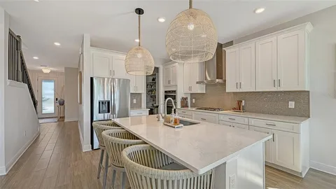 a kitchen with stainless steel appliances granite countertop a sink a refrigerator and a stove