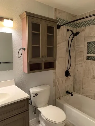 a bathroom with a toilet sink vanity and shower
