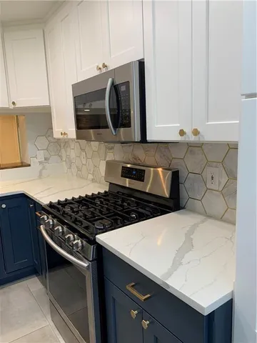 a kitchen with stainless steel appliances a stove a microwave a sink and cabinets