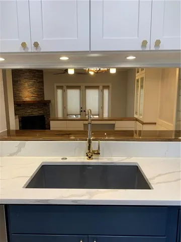 a view of a kitchen with kitchen island a sink and a stove