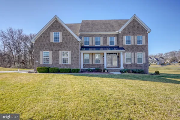 a brick house with a large pool in front of the house