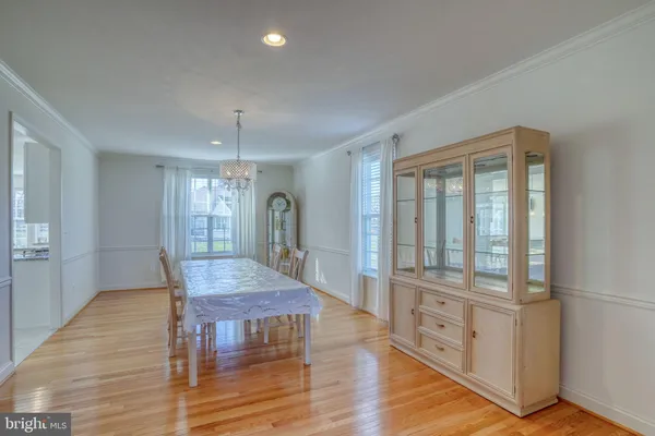 a dining room with wooden floor and floor to ceiling window