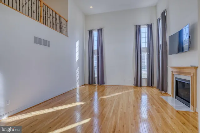 a dining room with wooden floor and floor to ceiling window