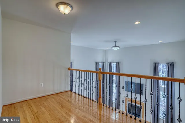 a room with furniture pool table wooden floor and windows