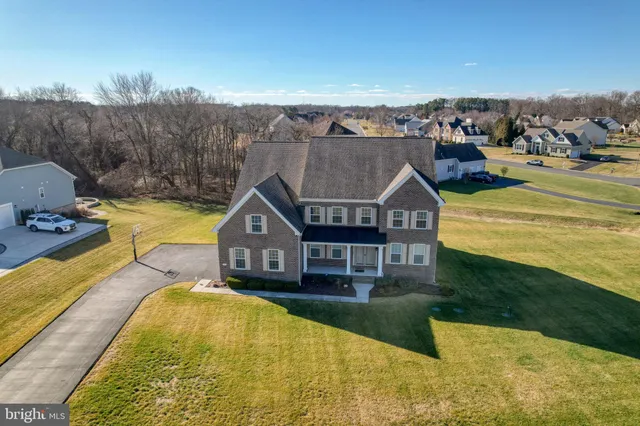 a view of a house with a big yard and large trees