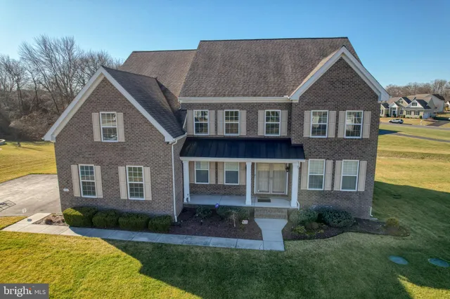 an aerial view of a house with a yard and lake view