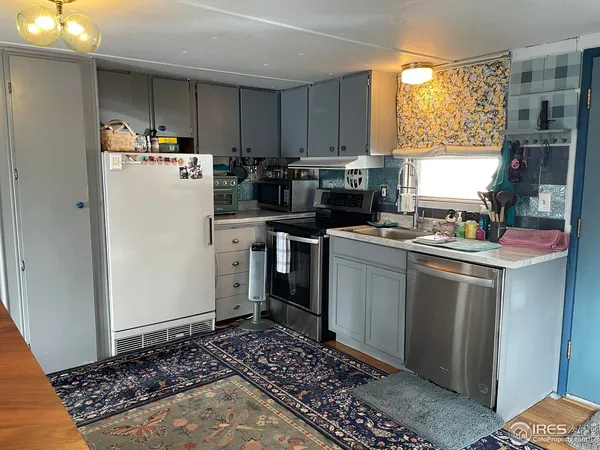 a kitchen with a refrigerator and a stove top oven