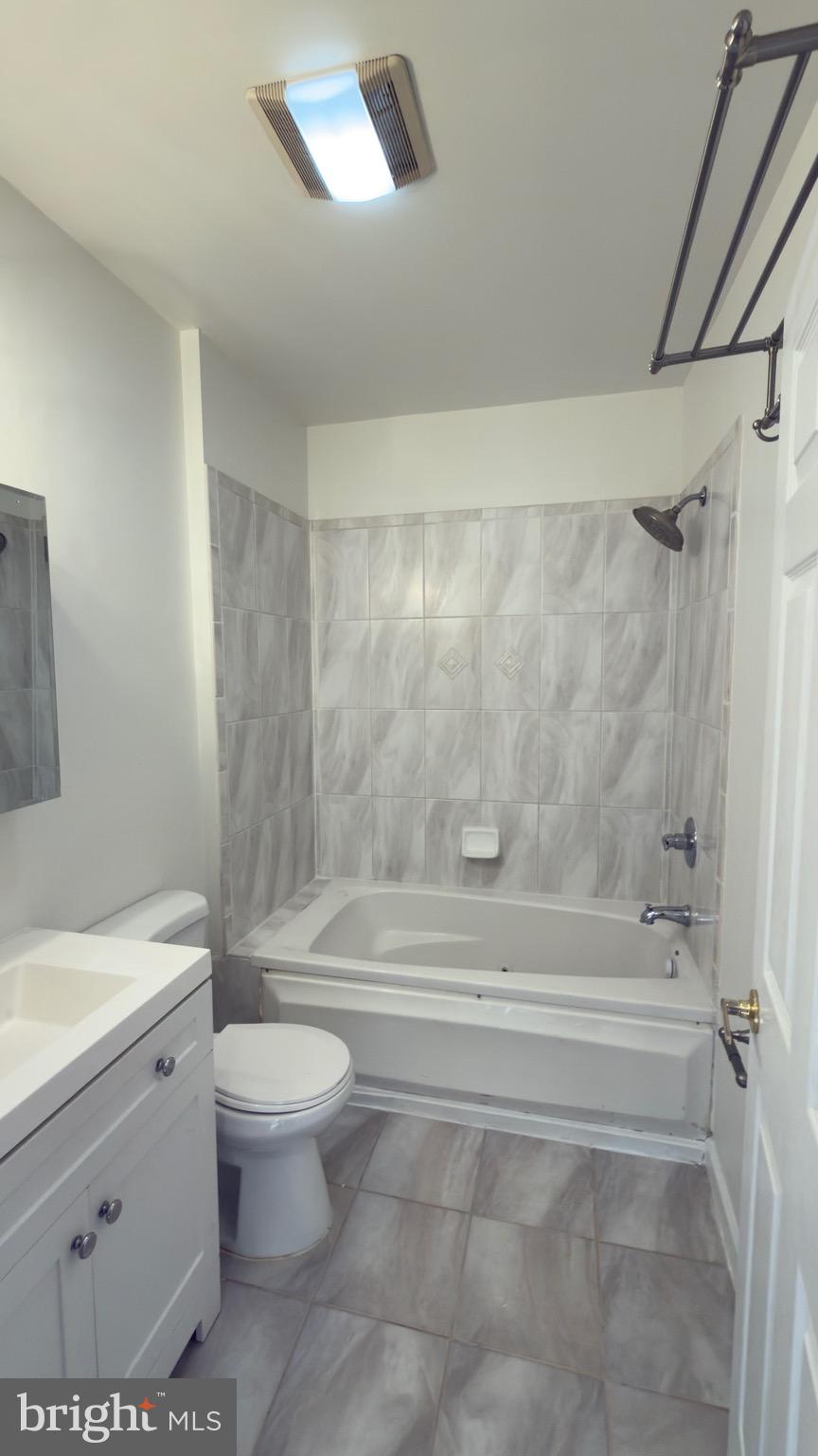 1117 7th Street Northeast Washington, DC 20002 - Photo 11 of 11 a bathroom with a bathtub shower sink vanity and toilet