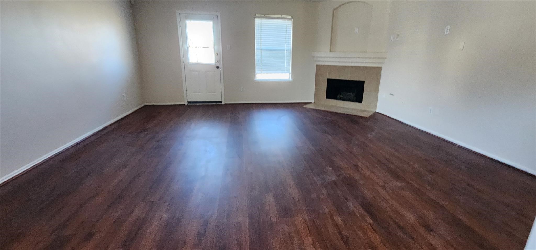 315 Sunset Colony Drive Rosharon, TX 77583 - Photo 8 of 20 an empty room with wooden floor fireplace and windows