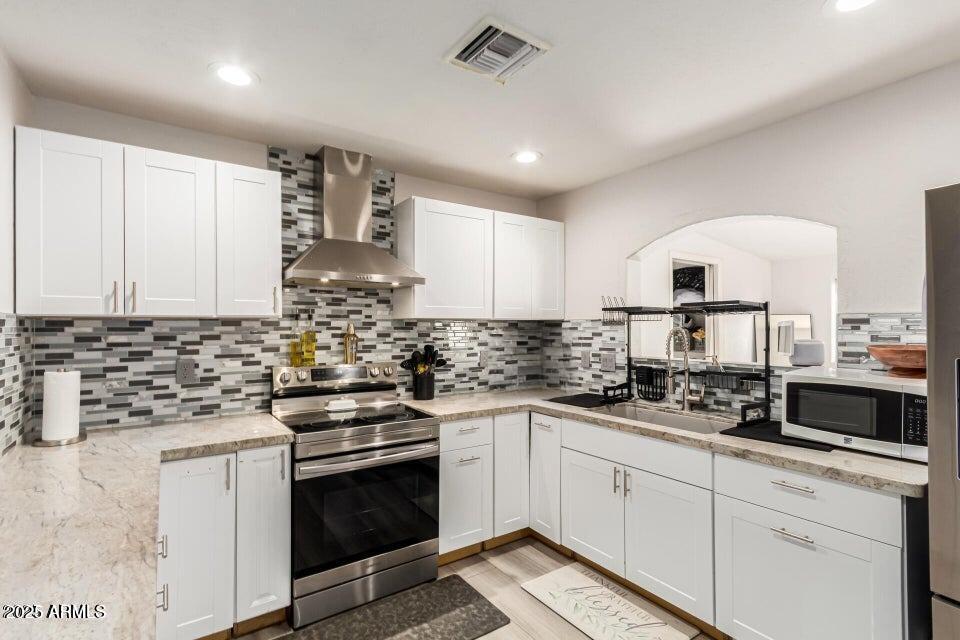677 West 22nd Avenue Apache Junction, AZ 85120 - Photo 2 of 21 a kitchen with stainless steel appliances a stove sink and cabinets