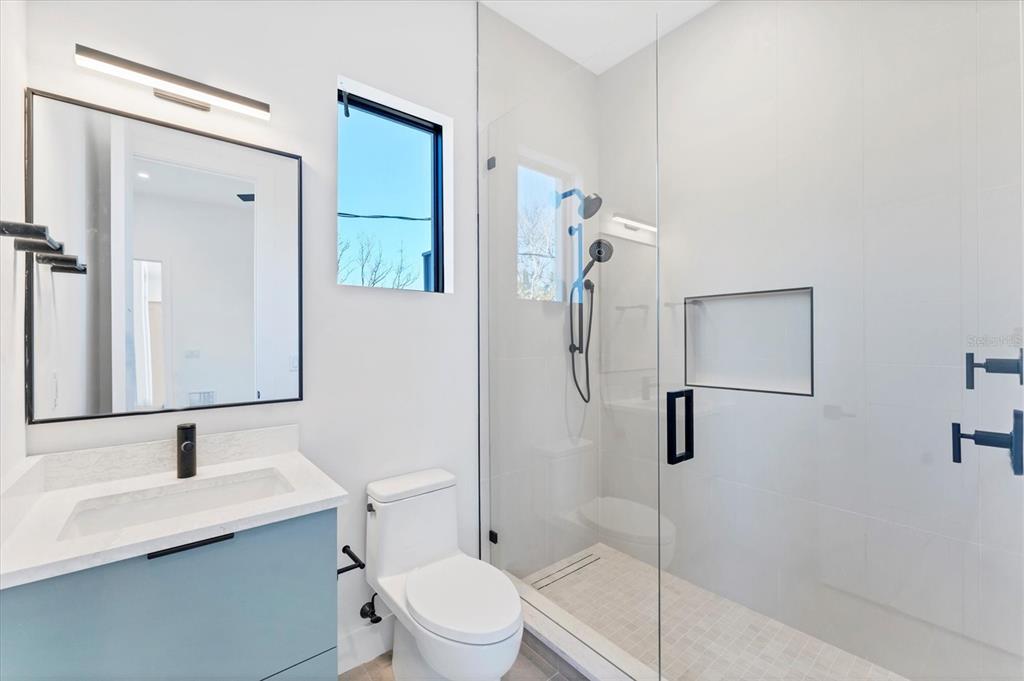 4005 Casey Key Road Nokomis, FL 34275 - Photo 37 of 84 a bathroom with a toilet sink shower and mirror