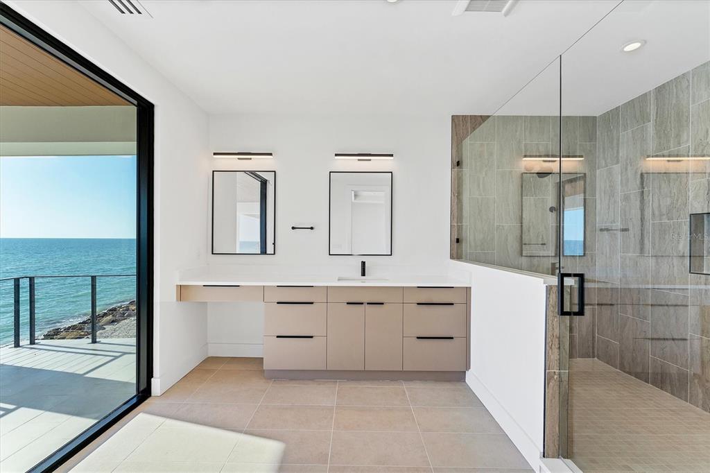 4005 Casey Key Road Nokomis, FL 34275 - Photo 46 of 84 a spacious bathroom with a shower sink and mirror