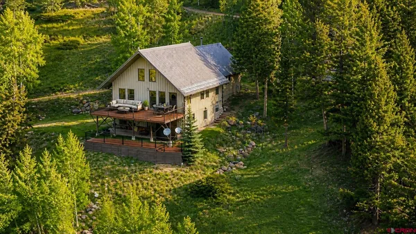 a view of a house with backyard and sitting area