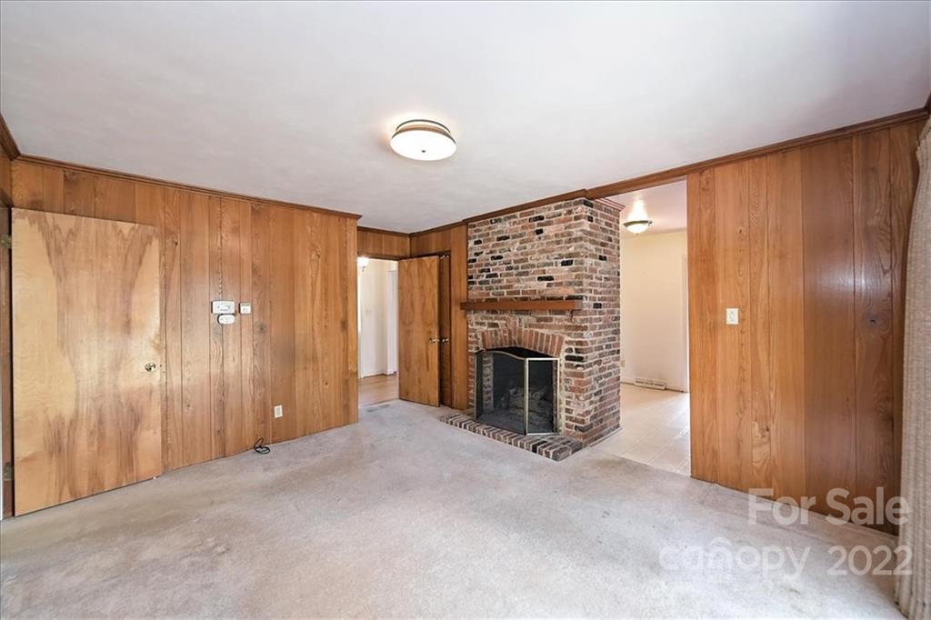 5714 Sharon Road Charlotte, NC 28210 - Photo 11 of 22 an empty room with a fireplace and painted walls