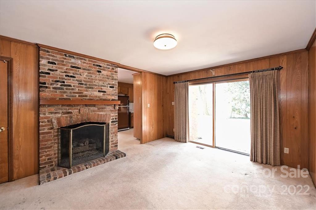 5714 Sharon Road Charlotte, NC 28210 - Photo 12 of 22 a view of an empty room with a fireplace and a window