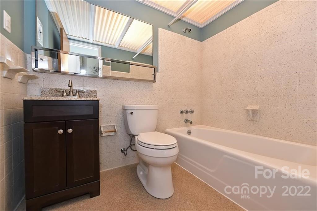 5714 Sharon Road Charlotte, NC 28210 - Photo 17 of 22 a bathroom with a toilet a sink and bathtub