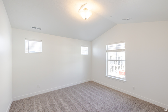 4662 Poplar Way, Unit Q303 Mapleton, UT 84664 - Photo 15 of 18 Spare room featuring vaulted ceiling, light colored carpet, and plenty of natural light