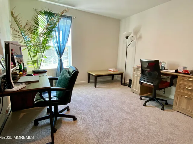 a view of a workspace with furniture and a window