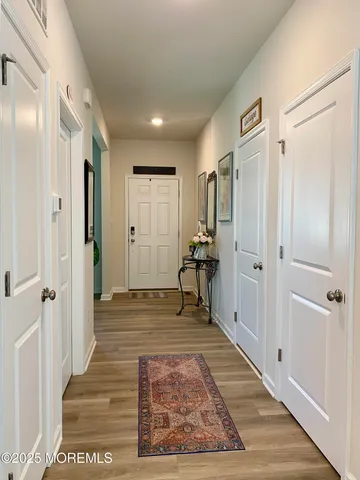 a view of a hallway with wooden floor and staircase