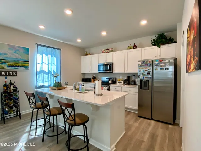 a kitchen with refrigerator and chairs