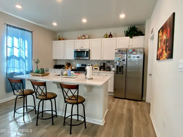 a kitchen with stainless steel appliances a refrigerator a stove a sink dishwasher with a dining table and chairs