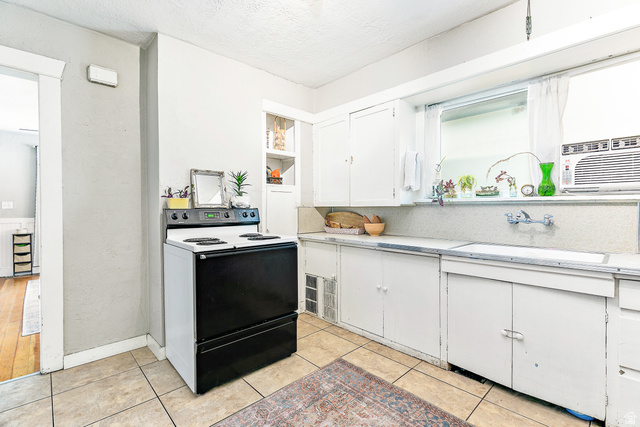 232 300 North Provo, UT 84606 - Photo 9 of 27 Kitchen with electric range, white cabinetry, a textured ceiling, and a textured wall