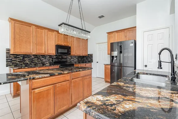 a kitchen with stainless steel appliances granite countertop a stove a refrigerator and a sink