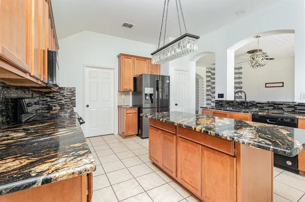 a kitchen with stainless steel appliances granite countertop a stove a sink and a refrigerator
