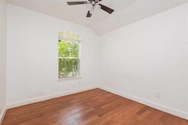 an empty room with a window and a ceiling fan