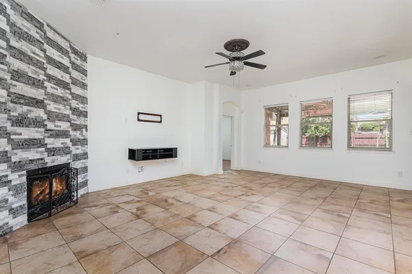 a view of an empty room with a fireplace and a window