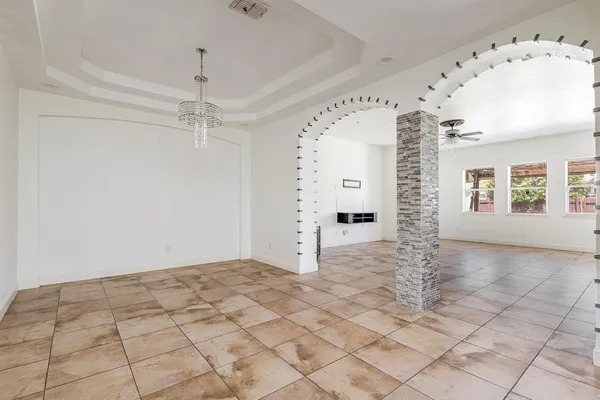 en empty room with window and chandelier