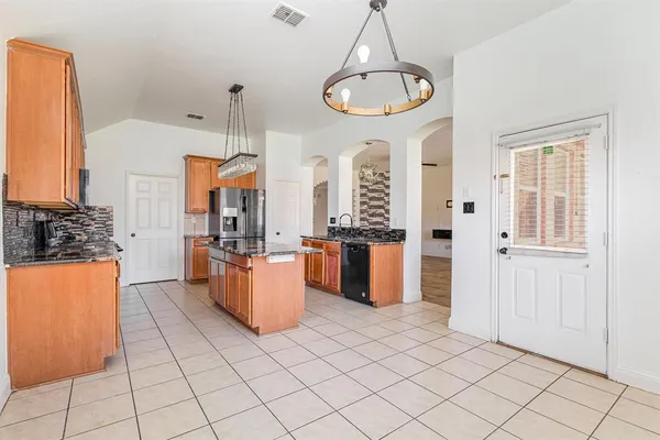 a kitchen with stainless steel appliances kitchen island granite countertop a refrigerator a stove a oven and a refrigerator