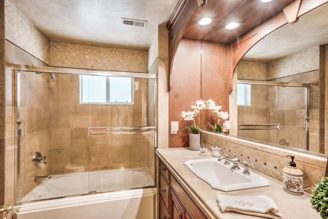 a bathroom with a bathtub shower sink and mirror