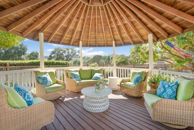 a balcony with furniture and umbrella