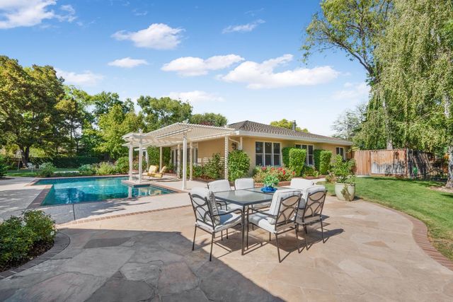 a view of a patio with a dining table and chairs with a yard